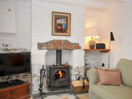 A living room with a fireplace and seating at Island House in Golant near Tywardreath