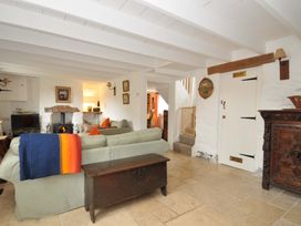 A living room with a fireplace and sofa at Island House in Golant near Tywardreath