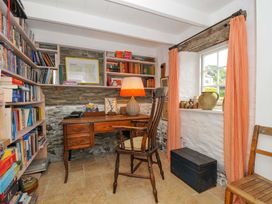 A study with a desk, bookshelf, and window at Island House Golant near Tywardreath