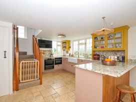A kitchen with cabinets and a staircase at Island House in Golant near Tywardreath