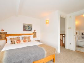 A bedroom with a bed and artwork at Island House in Golant near Tywardreath