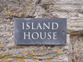 A sign with the name Island House on a stone wall at Island House in Golant near Tywardreath
