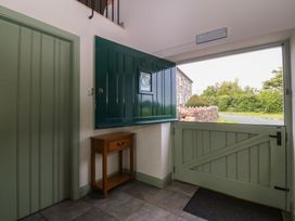 An entrance with a green door and a wooden table at No 1 The Granary in Capel Coch near Llannerch-Y-Medd