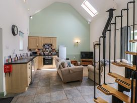 A living room and kitchen area with seating and appliances at No 1 The Granary Capel Coch near Llannerch-Y-Medd