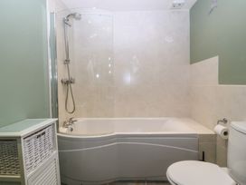 A bathroom with a bathtub and a shower at No 1 The Granary in Capel Coch near Llannerch-Y-Medd
