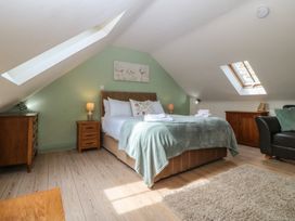 A bedroom with a bed and a dresser at No 1 The Granary in Capel Coch near Llannerch-Y-Medd