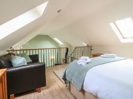 A loft with a bed and sofa at No 1 The Granary Capel Coch near Llannerch-Y-Medd