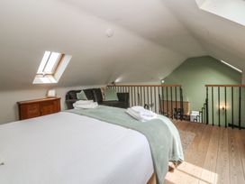 A loft with a bed and sofa at No 1 The Granary in Capel Coch near Llannerch-Y-Medd