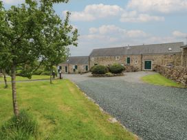A stone building with a gravel driveway at No 1 The Granary Capel Coch near Llannerch-Y-Medd