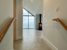 A hallway with a wood stove and a large window overlooking the sea at The Old Coastguard Lookout in Port Isaac