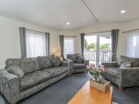 A living room with sofas and a coffee table at The Cotswold Holiday Lodge in Evesham