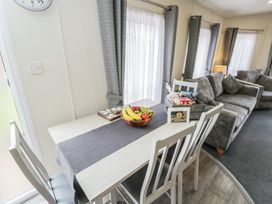 A dining area with a table and fruit at The Cotswold Holiday Lodge in Evesham