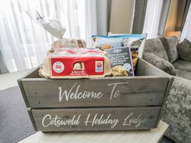 A basket with eggs, bread, and cookies at The Cotswold Holiday Lodge Evesham