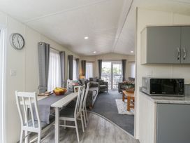 A living room with furniture and dining area at The Cotswold Holiday Lodge in Evesham