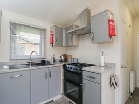 A kitchen with cabinets and an oven at The Cotswold Holiday Lodge in Evesham