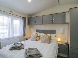 A bedroom with a bed and cabinets at The Cotswold Holiday Lodge Evesham