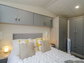 A bedroom with a bed and wardrobe at The Cotswold Holiday Lodge in Evesham