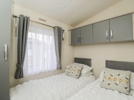 A bedroom with a bed and pillows at The Cotswold Holiday Lodge in Evesham