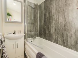 A bathroom with a bathtub and shower at The Cotswold Holiday Lodge in Evesham