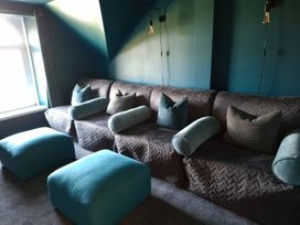 A snug with a sofa and cushions at Teifi Villa in St Dogmaels