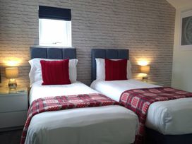 A bedroom with two single beds and lamps at Teifi Villa St Dogmaels