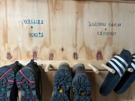 An entryway shoe rack with wellies and boots at Teifi Villa St Dogmaels