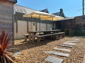 An outdoor area with a table and umbrella at Teifi Villa St Dogmaels