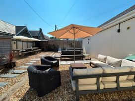 An outdoor seating area with a table and chairs at Teifi Villa St Dogmaels