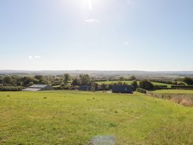 A landscape view with grass, trees and buildings at Foxes Den Allerston near Thornton Dale