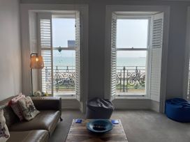 A living room with a sofa and a view of the sea at Sunrise Apartment in Weymouth
