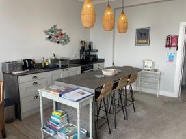 A kitchen with appliances and seating at Sunrise Apartment in Weymouth