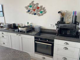 A kitchen with appliances and utensils at Sunrise Apartment in Weymouth