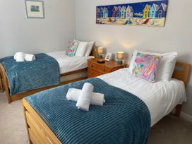A bedroom with two single beds and a painting at Sunrise Apartment in Weymouth