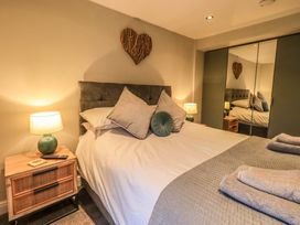 A bedroom with a bed and nightstand at West View in Leasgill near Milnthorpe