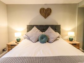 A bedroom with a bed and nightstands at West View in Leasgill near Milnthorpe