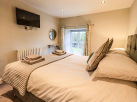A bedroom with a bed and television at West View Leasgill near Milnthorpe