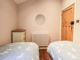 A bedroom with two beds and a wardrobe at West View in Leasgill near Milnthorpe