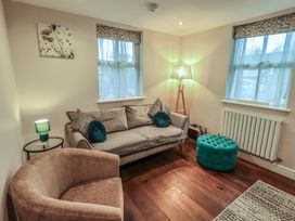 A living room with a sofa and armchair at West View in Leasgill near Milnthorpe