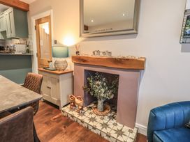A dining room with a fireplace and a mirror at West View in Leasgill near Milnthorpe