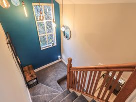 A staircase with wooden handrail and light fixtures at West View in Leasgill near Milnthorpe