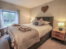 A bedroom with a bed and bedside table at West View in Leasgill near Milnthorpe