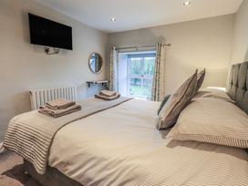 A bedroom with a bed and television at West View in Leasgill near Milnthorpe