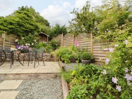 A garden with a seating area and flower beds at West View, Leasgill near Milnthorpe