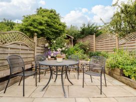 A garden with a table and chairs surrounded by plants at West View Leasgill near Milnthorpe