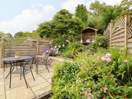 A garden with a table, chairs, and flowers at West View Leasgill near Milnthorpe