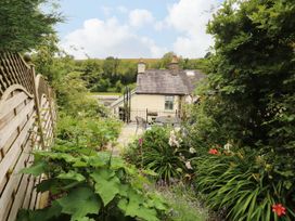 A garden with a house, table, and chairs at West View in Leasgill near Milnthorpe