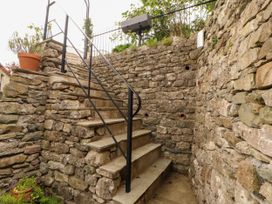 A stone stairway with a metal railing and a potted plant at West View in Leasgill near Milnthorpe