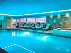 An indoor pool area with loungers and a jacuzzi at The Boats in St Ives