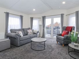 A living room with a sofa and armchair at Happy Daze Carnaby near Bridlington