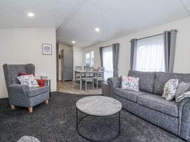 A living room with a sofa and coffee table at Happy Daze in Carnaby near Bridlington